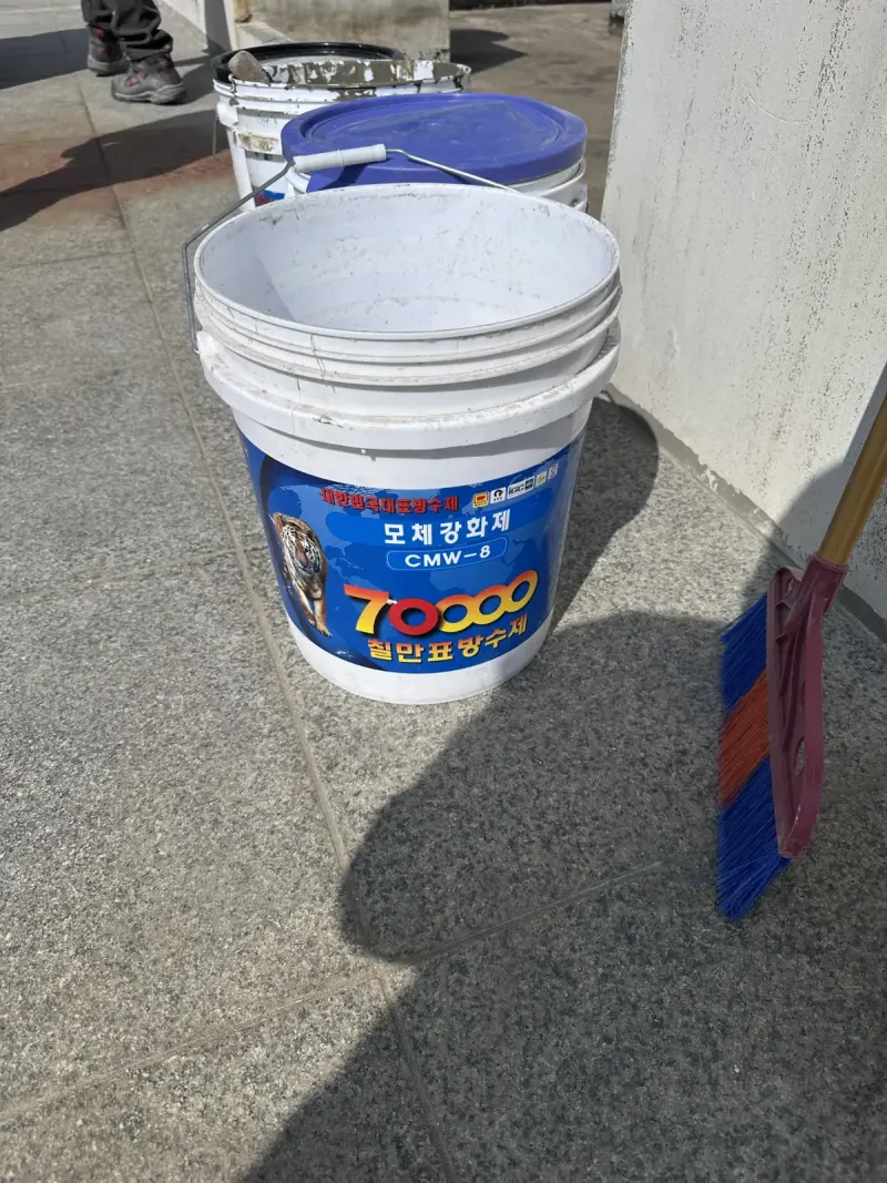 방수 자재통과 빗자루가 놓인 옥상 바닥